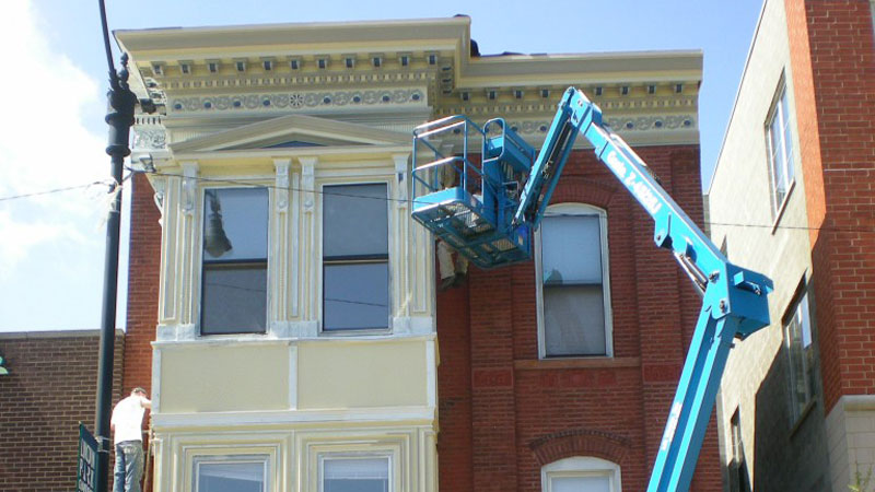 Blue cherry picker near the outside of a building